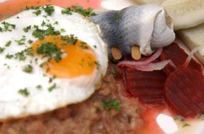 Eine Portion Labskaus mit Spiegelei, roter Beete und einem Rollmops