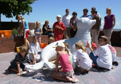 Grundschulkinder gestalten die Robben-Skulptur.