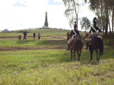 Historische Reiter lenken ihre Pferde in Richtung des Gefallenen-Denkmals