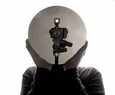 Ich im Studio, einen Spiegel vor dem Gesicht, so dass die Kamera das fotografiert, was sie ist und was das Bild ohnehin immer macht, auch wenn ich hinter der Kamera stünde.