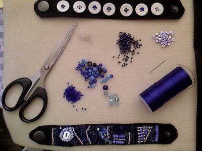 Sticken-Arbeitsplatz, eine Matte mit Schere, Faden, Perlen und zwei Armbänder Sticken-Arbeitsplatz, eine Matte mit Schere, Faden, Perlen und zwei Armbänder