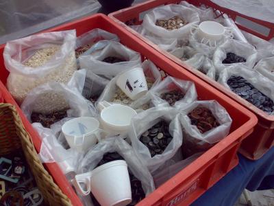 Säckerweise Knöpfe für einen Euro pro Tasse in einem Korb ausgestellt