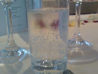 Ein Wasserglas, leicht beschlagen steht vor einem Weißweinglas