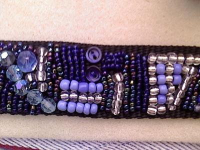 Das Mittelstück eines Armbandes, gestickt mit unterschiedlichen Perlen, die nicht ordentlich sondern scheinbar chaotisch angeordnet sind Das Mittelstück eines Armbandes, gestickt mit unterschiedlichen Perlen, die nicht ordentlich sondern scheinbar chaotisch angeordnet sind