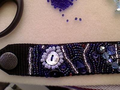 Ein Ende eines Armbandes, mit Perlen bestickt. Besonderes Merkmal hier ist der Perlmuttknopf Ein Ende eines Armbandes, mit Perlen bestickt. Besonderes Merkmal hier ist der Perlmuttknopf