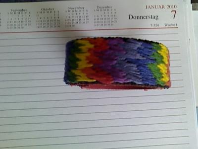 Armband in Regenbogenfarben gestickt mit Klettverschluss und Leder-Futter in Rot Armband in Regenbogenfarben gestickt mit Klettverschluss und Leder-Futter in Rot