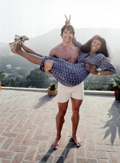 Arnold Schwarzenegger nimmt Donna Summer auf den Arm