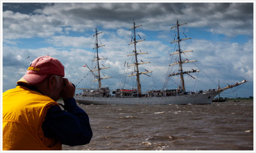 Mann fotografiert die Ausfahrt eines Segelschiffes