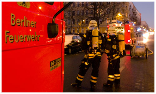 Feuerwehrfahrzeuge mit Feuerwehrleuten